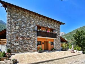 um edifício de pedra com uma varanda em cima em Casa Ferro em Plan