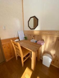 a wooden table and chair in a sauna at Azumino Backpackers in Matsukawa