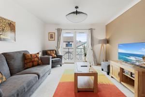 a living room with a couch and a tv at Quayside House by Staytor Accommodation in Exeter