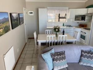 赫爾羅德灣的住宿－Herolds Bay Accommodation - Hiers Ons Weer Upstairs，客厅以及带沙发和桌子的厨房。