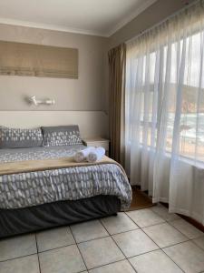 a bedroom with a bed and a large window at Herolds Bay Accommodation - Hiers Ons Weer Upstairs in Herolds Bay