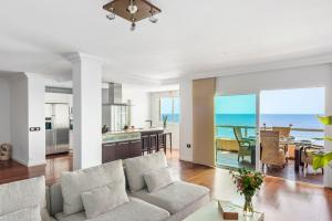 a living room with a couch and a view of the ocean at Spacious beach apartment with private parking in Radazul