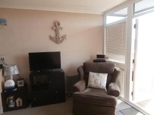 a living room with a chair and a tv at Beautiful 2-Bed Chalet in Mablethorpe in Mablethorpe
