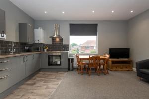 a kitchen and dining room with a table and chairs at Cosy, modern one bedroom apartment close to Durham in Bowburn