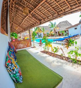 an outdoor area with a green mat in front of a pool at Ananda Beach Hotel in Paje