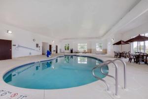 una gran piscina en una gran habitación con mesas y sillas en Comfort Inn Plover-Stevens Point en Plover