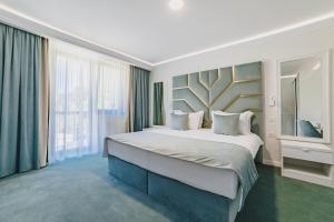 a bedroom with a large bed and a large window at 3 Stejari Brasov in Braşov