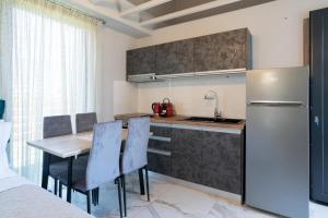 a kitchen with a table and a refrigerator at OLYMPUS Paradise 4 in Skotina