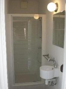 een badkamer met een douche en een witte wastafel bij B&B Pittoresque in Houffalize