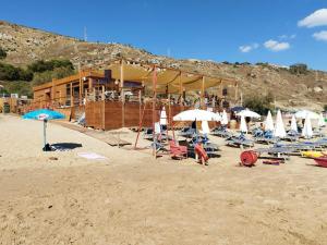 a group of chairs and umbrellas on a beach at Appartamento Le Rondini in Siculiana