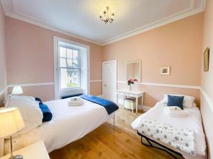 a bedroom with two beds and a window at Remarkable 5BR Townhouse with Garden, Sleeps 12 in Edinburgh