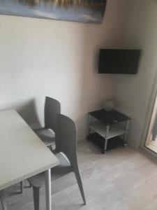a room with two chairs and a table and a television at Corsica studio Face à la mer Moriani plage in San-Nicolao