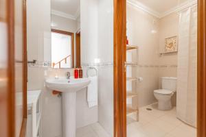 a white bathroom with a sink and a toilet at The ocean house in Baleal