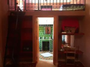 Zimmer mit einem Etagenbett und einer Tür, die in ein Zimmer führt. in der Unterkunft Kasbah Petit Nomade in Tinghir