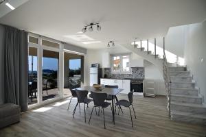 a kitchen and dining room with a table and chairs at Eleonas View Suites in Nea Peramos