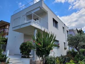 een wit gebouw met een balkon bij Garda view - Nuovo appartamento con solarium vista lago in Garda
