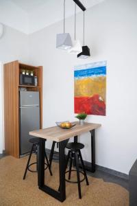 a table with a bowl of fruit and a painting on the wall at HomeResidence 1 in Ermoupoli