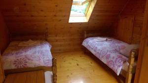 a bedroom with two beds in a wooden cabin at Apartment Pretner, Lepena in Soča