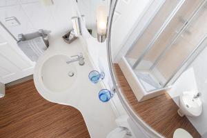 a bathroom with a toilet with blue glasses on it at Hotel Schlösschen Sundische Wiese Zingst in Zingst +63 photos