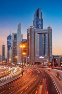 Una ciudad de noche con tráfico en una autopista en Fairmont Dubai, en Dubái