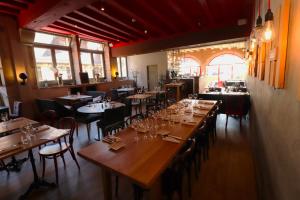 a restaurant with tables and chairs with wine glasses at Le Corbeau in Auxonne