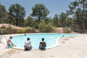 tres hombres sentados en una piscina en Villa Remi, Piscine Proche Océan, en Moliets-et-Maa