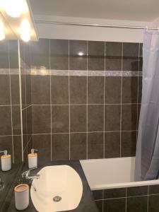 a bathroom with a sink and a bath tub at Bel appartement neuf climatisé & parking in Perpignan