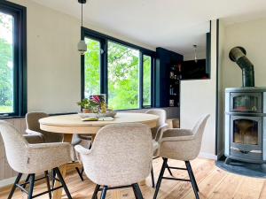 een eetkamer met een tafel en stoelen en een fornuis bij Idyllic house with 360 view of nature in Dalfsen