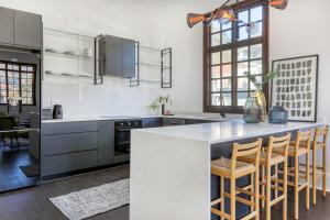 eine Küche mit einer großen Insel mit Barhockern in der Unterkunft Secure & Central: Villa with Views of Table Mountain in Kapstadt