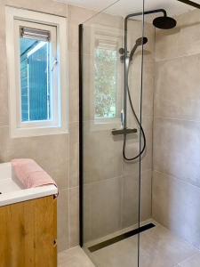 een douche met een glazen deur in de badkamer bij Idyllic house with 360 view of nature in Dalfsen