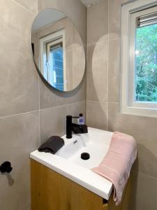 een badkamer met een witte wastafel en een spiegel bij Idyllic house with 360 view of nature in Dalfsen