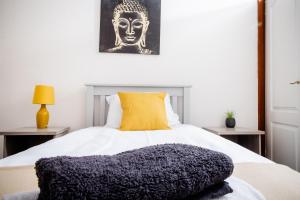 una camera da letto con un grande letto bianco con un cuscino giallo di Rigside House a Douglas