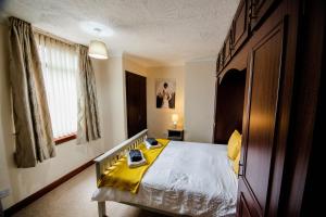 um quarto com uma cama com um cobertor amarelo em Rigside House em Douglas