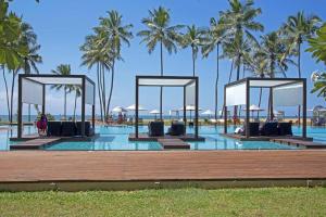 una piscina en el complejo con palmeras en el fondo en Suriya Resort, en Wayikkal