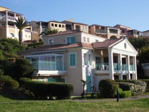 une grande maison blanche avec un palmier et des bâtiments dans l'établissement Cozy Apartment in Agay with Stunning Views, à Agay