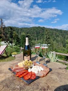 a table with a bottle of wine and wine glasses at Apartmani Jarevac in Bajina Bašta