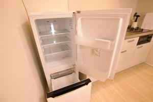 Biała lodówka z otwartymi drzwiami w kuchni w obiekcie Hotel Southern Suite Kugai w mieście Miyako-jima