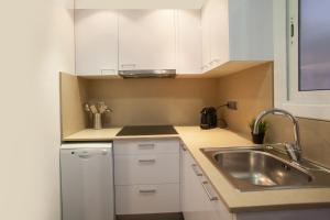 P9mdr1070 - Nice apartment in Poble Sec في برشلونة: مطبخ مع دواليب بيضاء ومغسلة