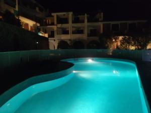 una piscina iluminada por la noche en Il Borgo Del Sole en Villasimius