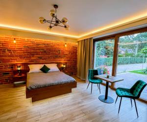 a bedroom with a brick wall and a bed and a table at Domek pod Katalpami in Głowno