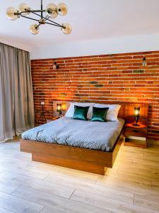 a bedroom with a brick wall and a bed at Domek pod Katalpami in Głowno