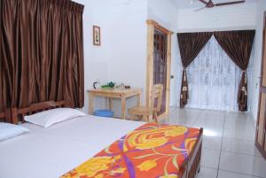 a bedroom with a bed and a table and a window at Jojies Homestay Fortkochi in Cochin