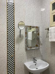 een badkamer met een wastafel en een spiegel bij ABHASKY in Abha