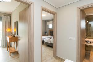 Pokój z łóżkiem i drzwiami prowadzącymi do sypialni w obiekcie Zante Suites w Alikanás
