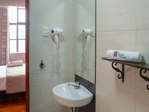 baño con lavabo y teléfonos en la pared en La Quinta de Amat, en Lima