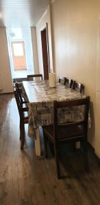 a dining room table with chairs and a wooden floor at Ljósavatn Guesthouse in Thingeyjarsveit