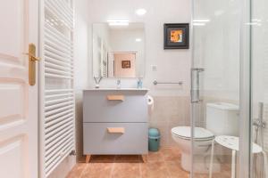 a white bathroom with a toilet and a sink at Orillas del Turia in Teruel +29 photos