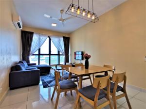a living room with a table and chairs and a couch at Eco Nest @3BEDROOM High floor By HauzCinta in Gelang Patah