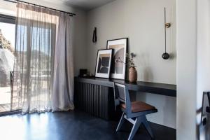 a desk with a chair in a room with a window at Nimbus Santorini in Oia