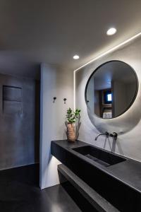 a bathroom with a black sink and a mirror at Nimbus Santorini in Oia